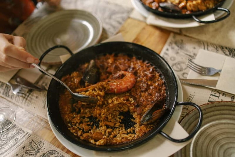 Barcelona: Food Walking Tour with Tapas and Wine - Tasting bravas, croquettes, pimientos, and paella
